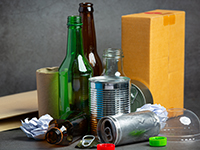 Small variety of traditional recyclables including empty glass bottles, empty aluminum and dry cardboard