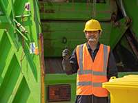 Man standing in front of solid waste collection vehicle