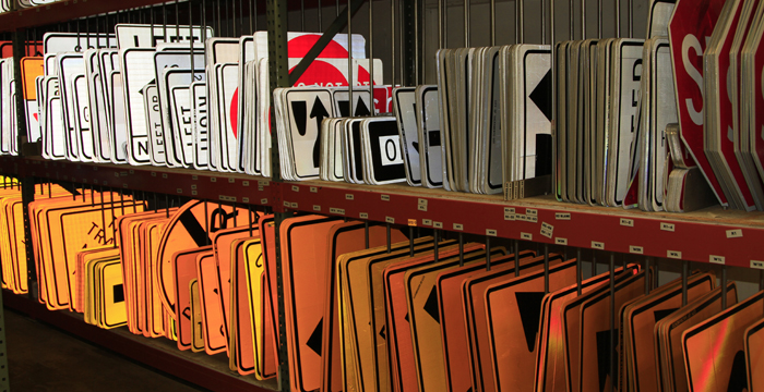 Traffic signs arranged on shelves in the signs and markings shop